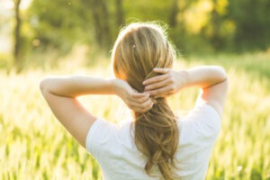 Woman walking in wheat field. Summer Hair Protection Guide for Mature Hair