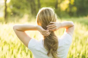 Woman walking in wheat field. Summer Hair Protection Guide for Mature Hair