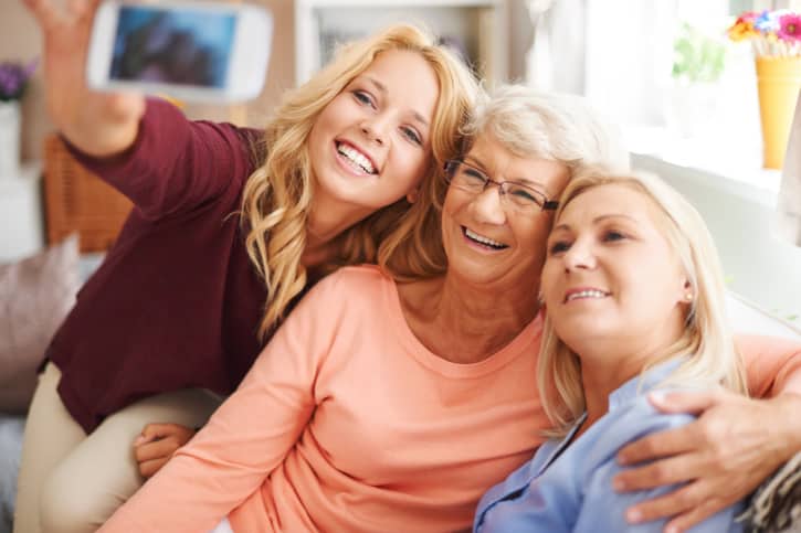 Blonde girl taking selfie with mom and grandma