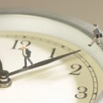 Businessmen figurines walking on a clock