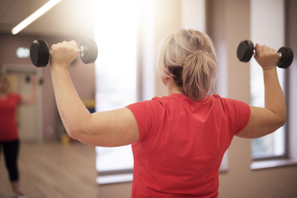 Rear view of Woman lifting weights as part of a weight lifting routine