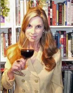 Liz Thach with wine glass and books