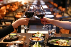 Romantic dinner with wine glasses eating Filet Mignon with Mustard and Mushrooms