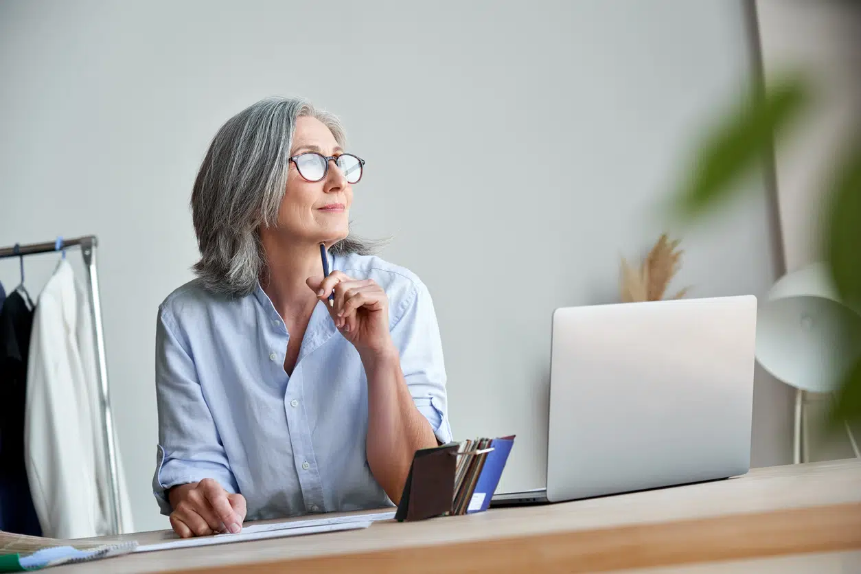 Working woman sitting at her desk thinking