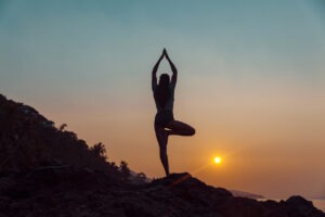Woman practicing yoga on the beach. How to do Tree Pose