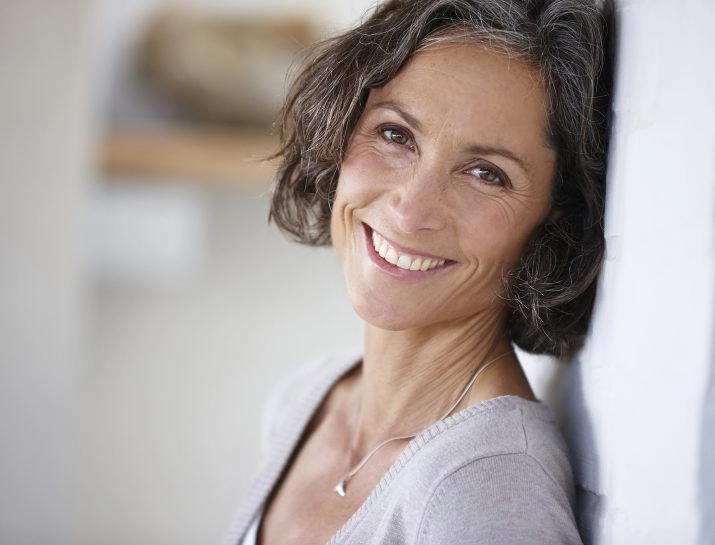 beautiful gray haired woman leaning on a wall