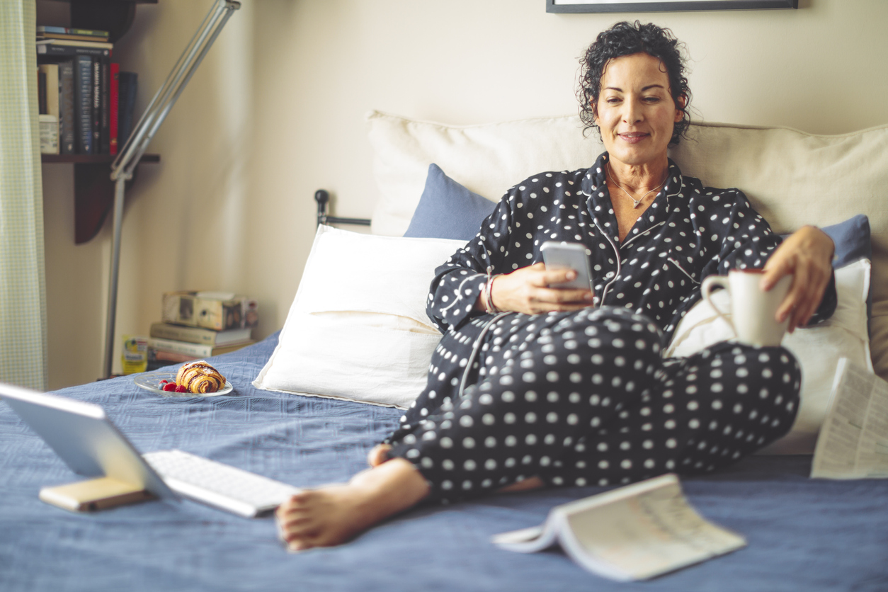 Mature Woman in Bed Answering Emails