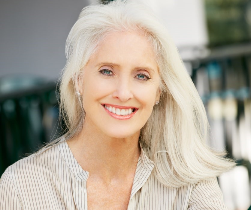 Femme aux cheveux gris buvant du café dans un café