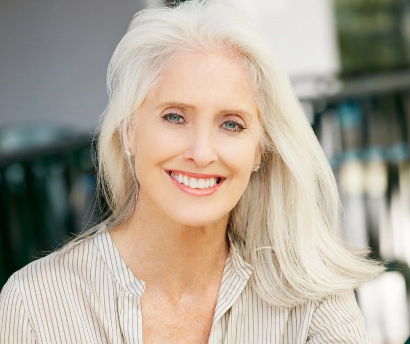 Woman with grey hair drinking coffee at a cafe