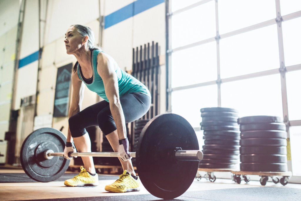 Mature Woman Lifting Weights in Gym Setting