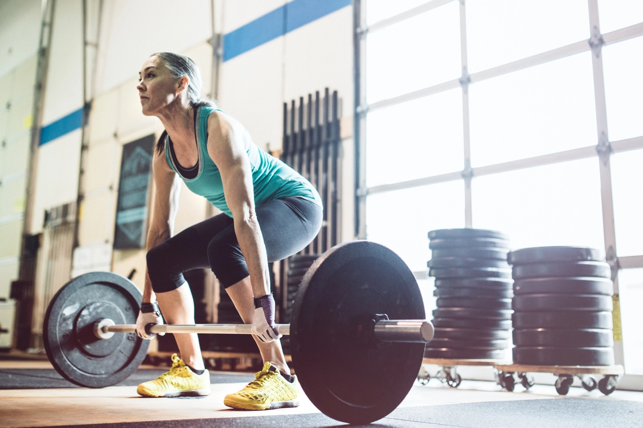 Mature Woman Lifting Weights in Gym Setting