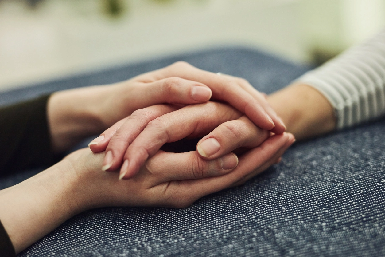 grieving friends holding hands