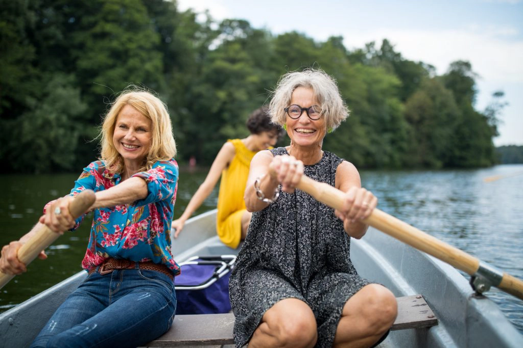 women inspiring women Smiling female friends rowing boat in lake