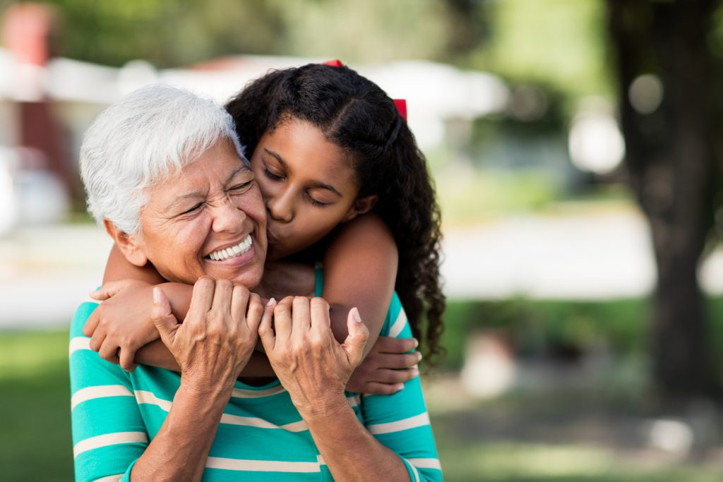 GRANDPARENTING TIPS Loving teen girl embracing and kissing grandmother