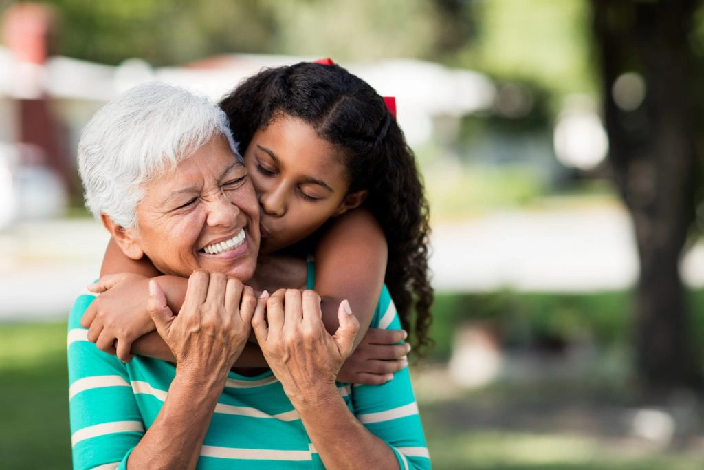 GRANDPARENTING TIPS Loving teen girl embracing and kissing grandmother