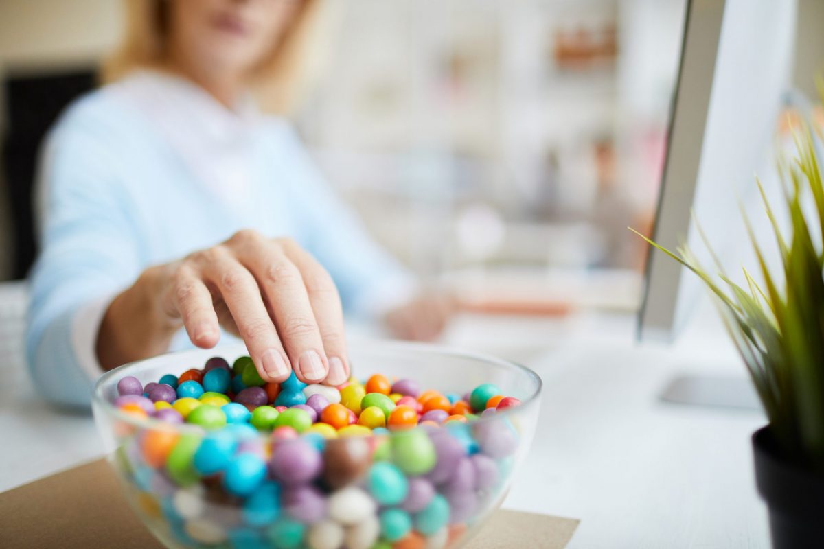 daily sugar intake - woman eating from a bowl of candy