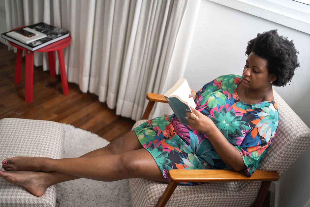 Woman at home sitting reading a book