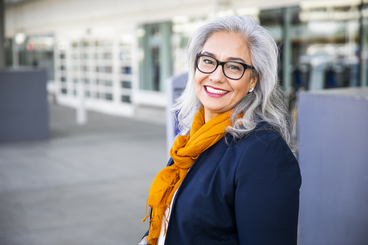 Gray haired woman in a blazer with a fashionable scarf