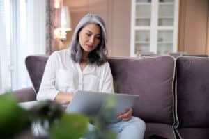 Calm lady with gadget working at home stock photo
