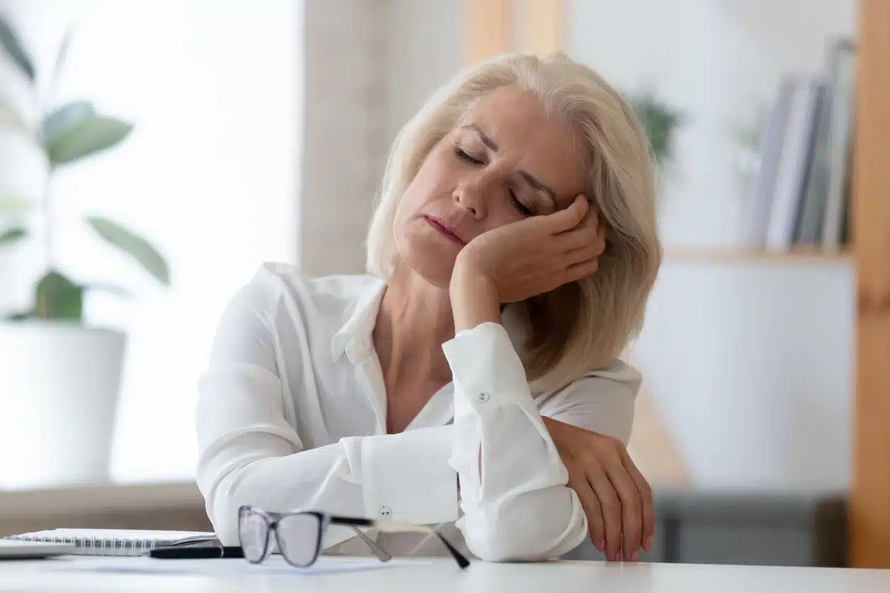 Tired or exhausted woman sitting at table