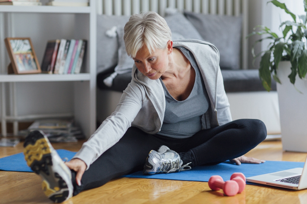 Best Fitness apps for Women over 50 - Woman Stretching at home
