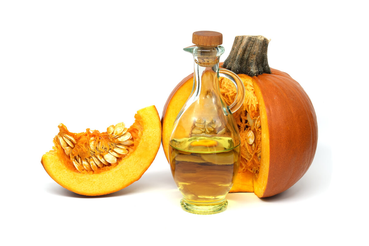 Pumpkin oil in decanter and fresh pumpkin