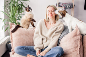 pros and cons of pets as an empty nester; woman with cat and dog on couch