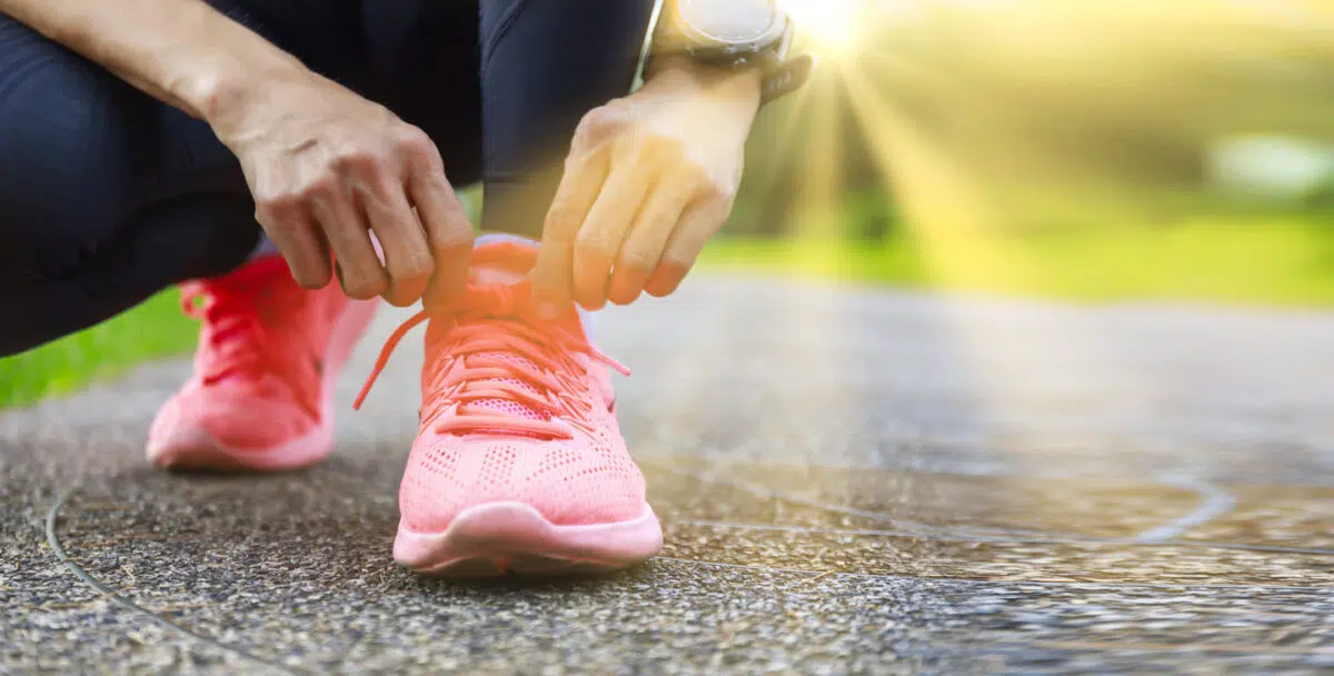 Woman putting on walking or running shoes, workout, exercise