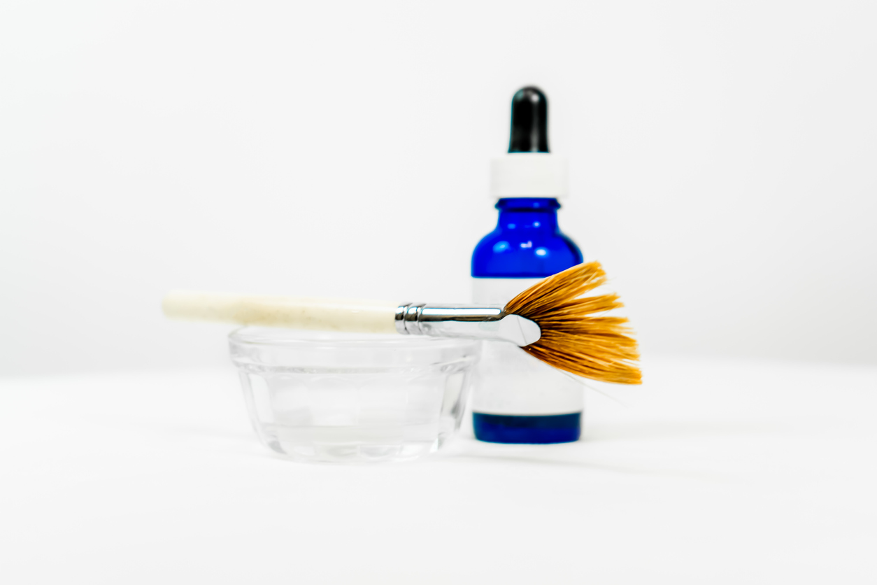 AHA vs BHA for chemical exfoliants - stock photo of a bottle and chemical peel applicator