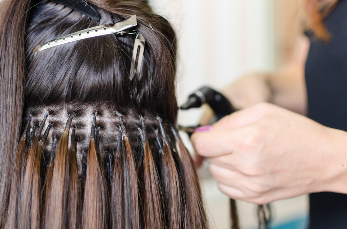 Woman getting hair extensions at the salon