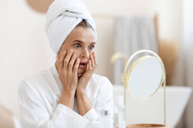 Menopausal acne; woman looking in the mirror, woman after a shower