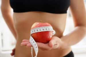 Galveston diet, diet review, woman with apple and measuring tape