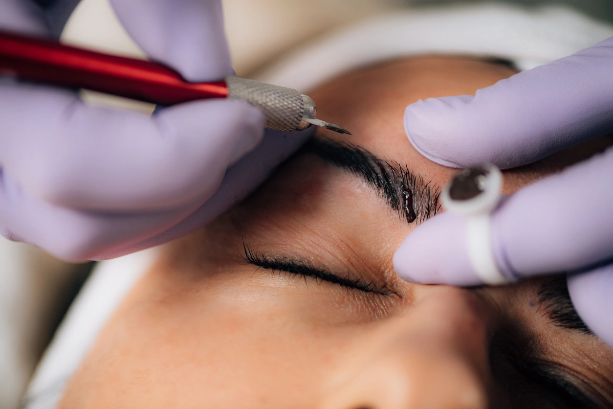 Woman microblading eyebrows