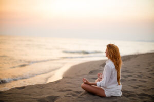 Woman doing yoga on the beach for exercise and hair growth