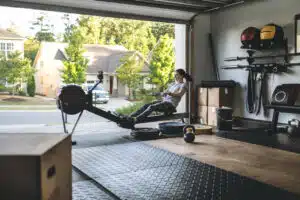 Best exercise equipment - woman in garage home gym working out on rowing machine