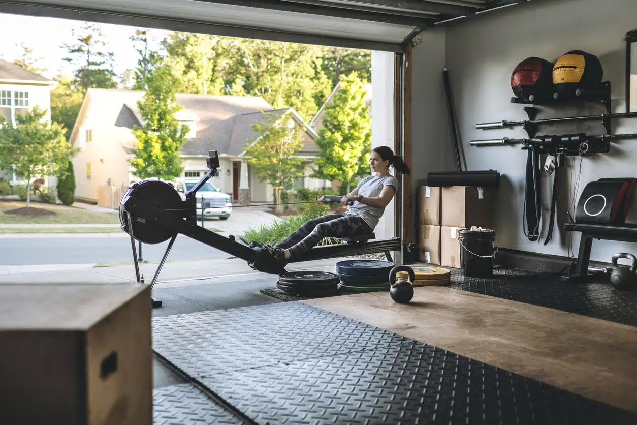 Best exercise equipment - woman in garage home gym working out on rowing machine