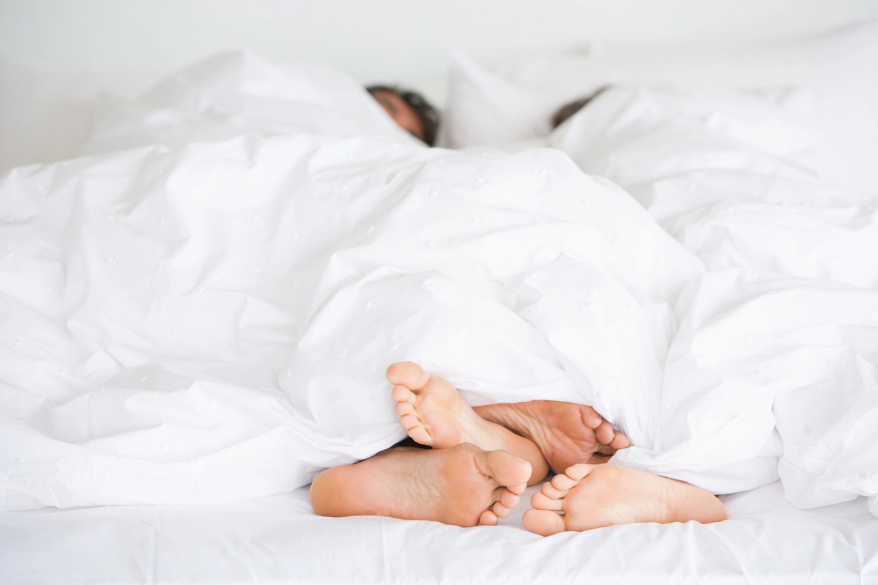 Couple in bed together, showing feet