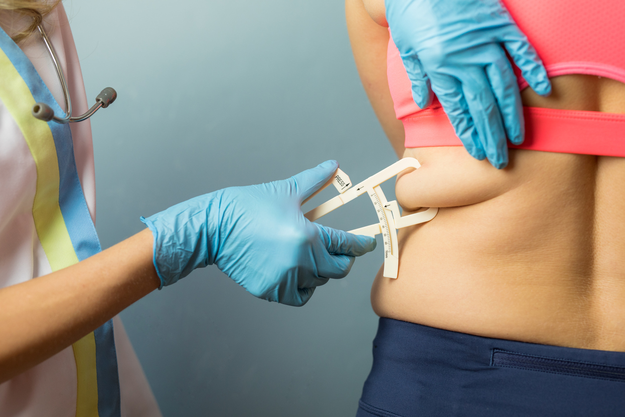 Doctor using body fat caliper