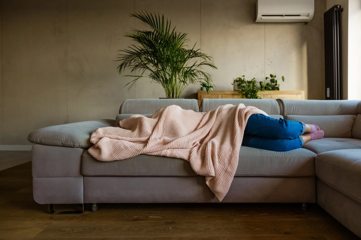 Woman sleeping on couch - crashing fatigue from menopause