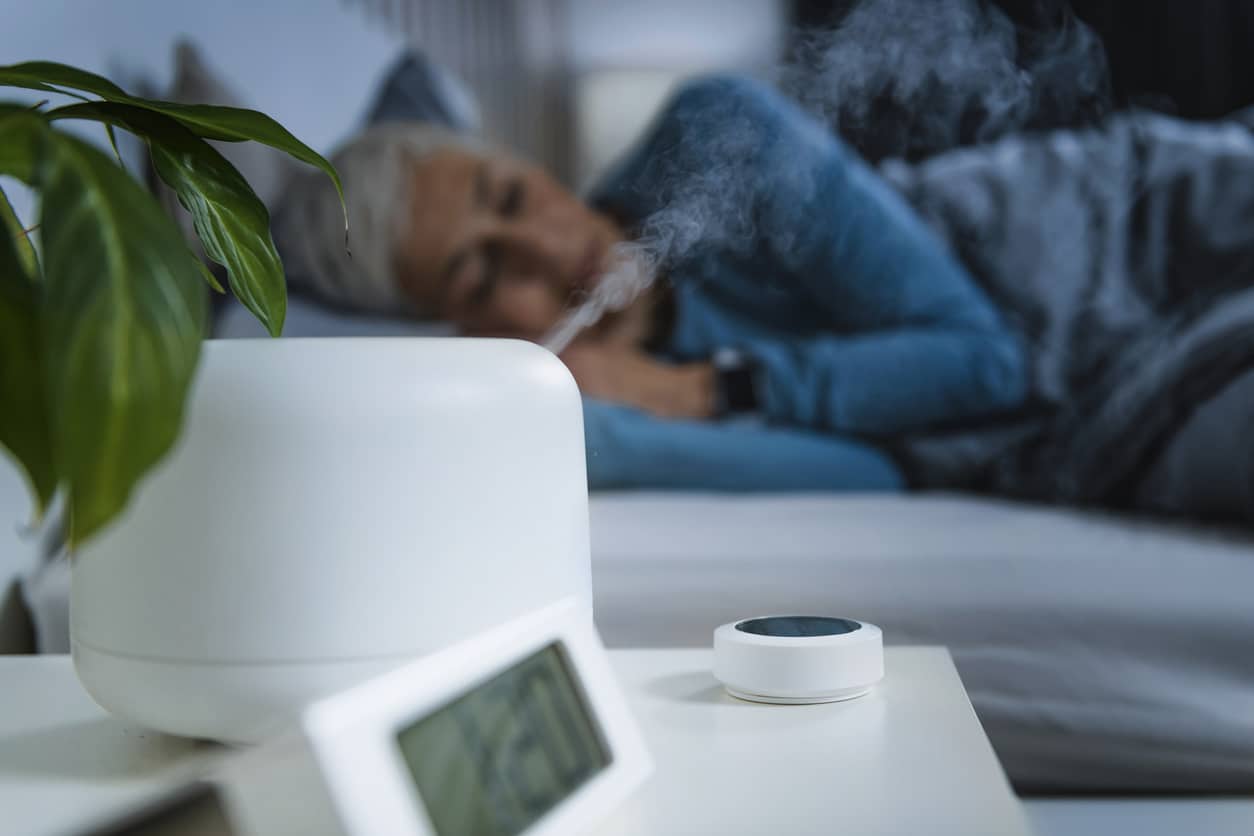 woman sleeping with humidifier to help with menopause and snoring
