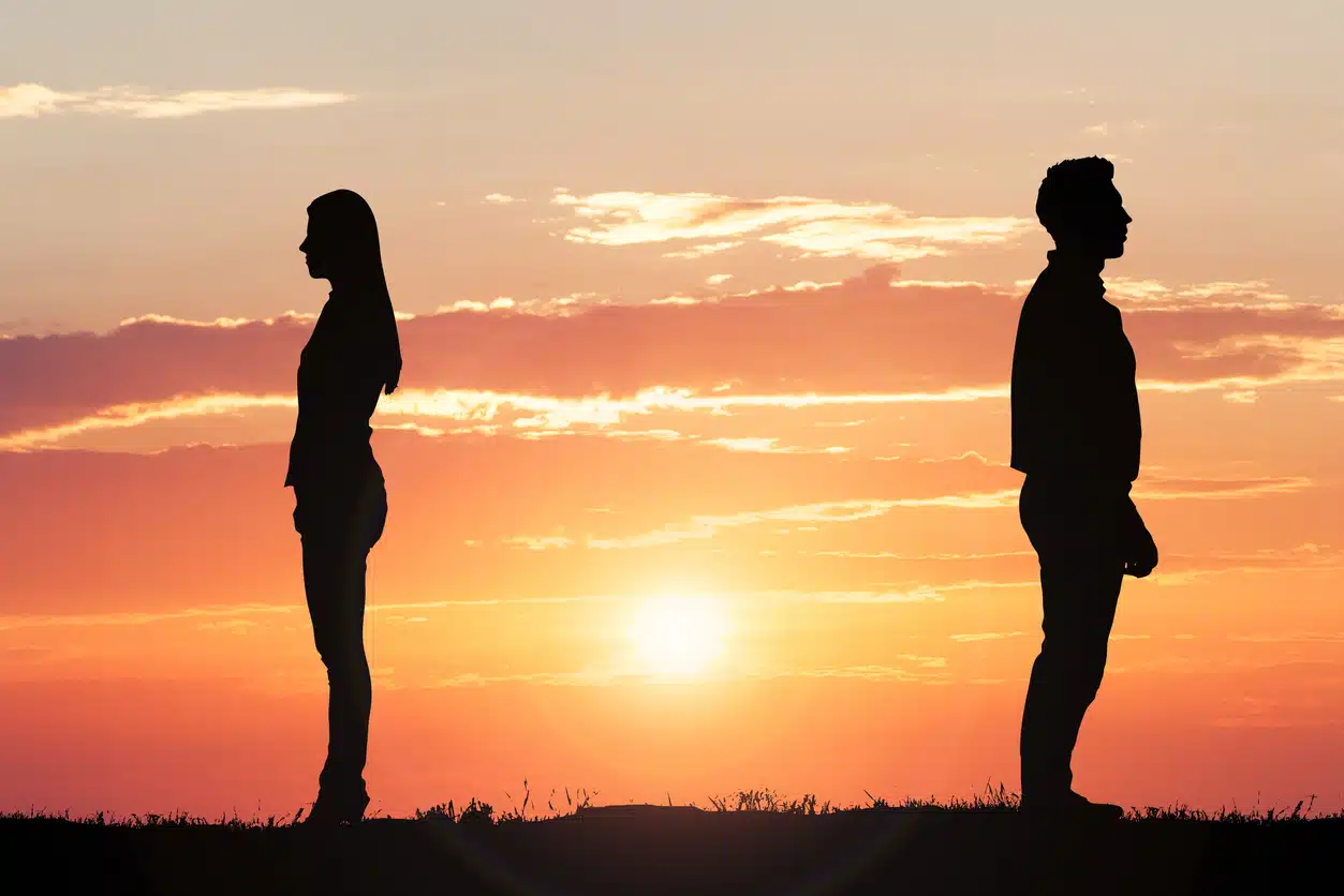 Silhouette of a couple standing apart indicating a breakup