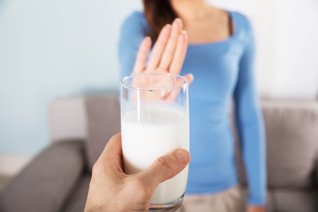 Woman declining glass of milk for elimination diet