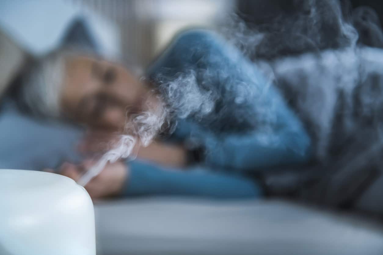 woman sleeping with a humidifier for sinus relief