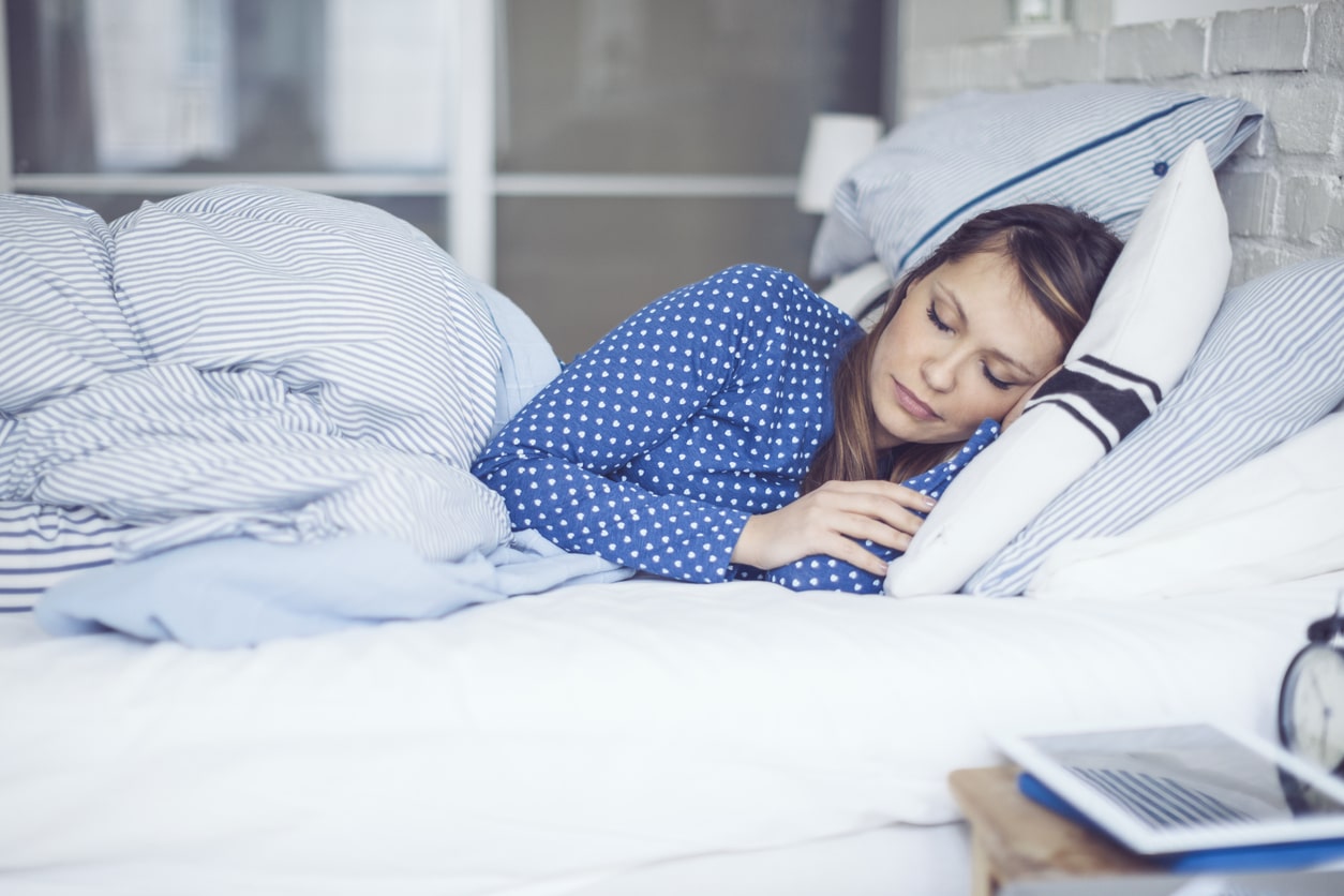 woman sleeping with extra pillows to aid with sinus drainage