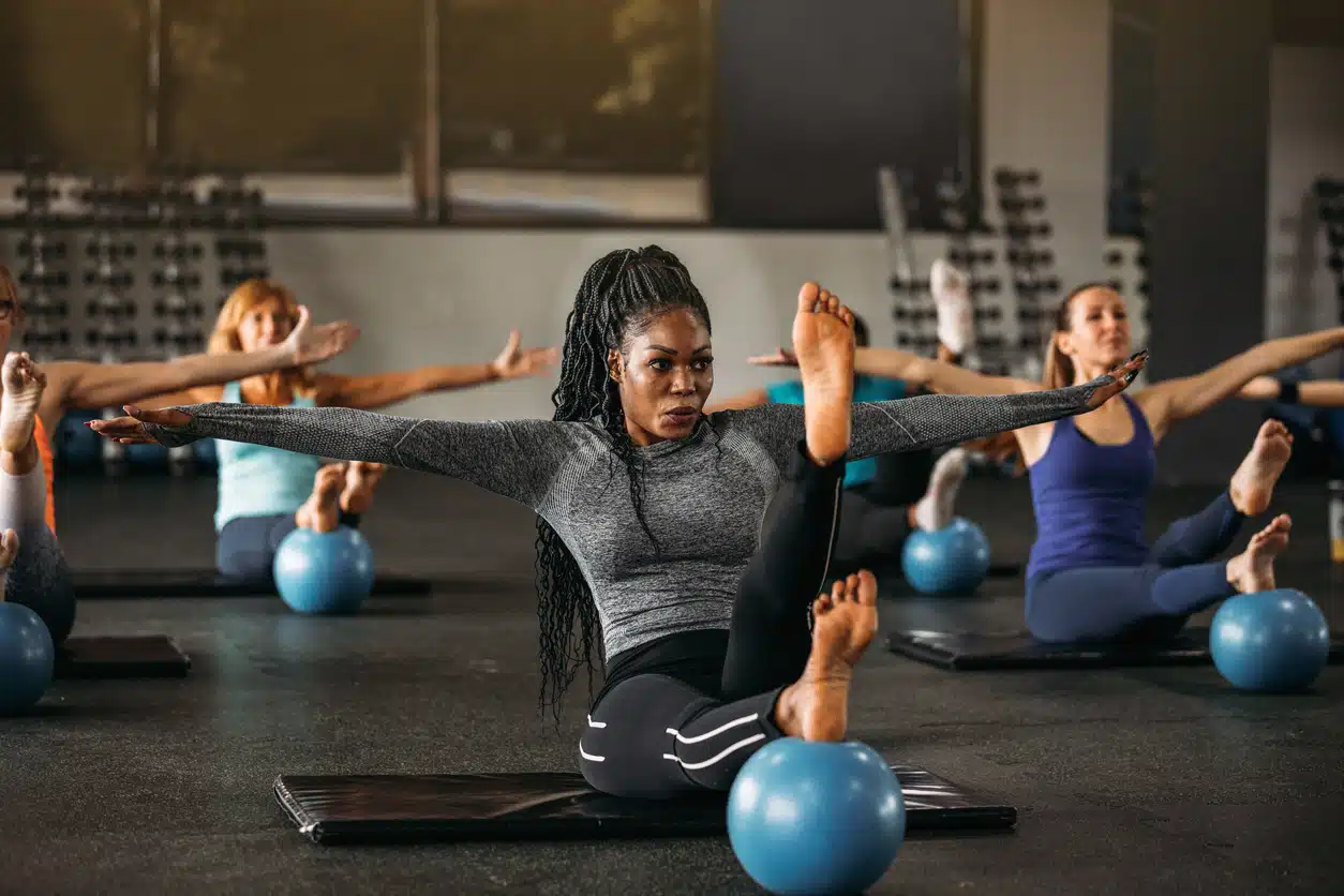 African American woman working out at gym doing leg lifts, exercise, weight gain