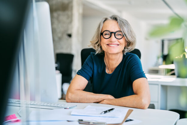 Confident woman sitting at her desk smiling