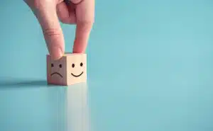 Mastering emotions - block showing a happy or sad face - choose your mood