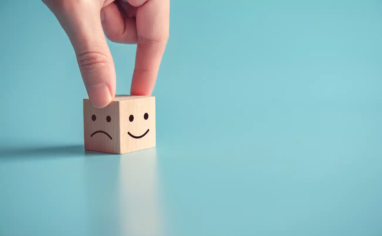 Mastering emotions - block showing a happy or sad face - choose your mood