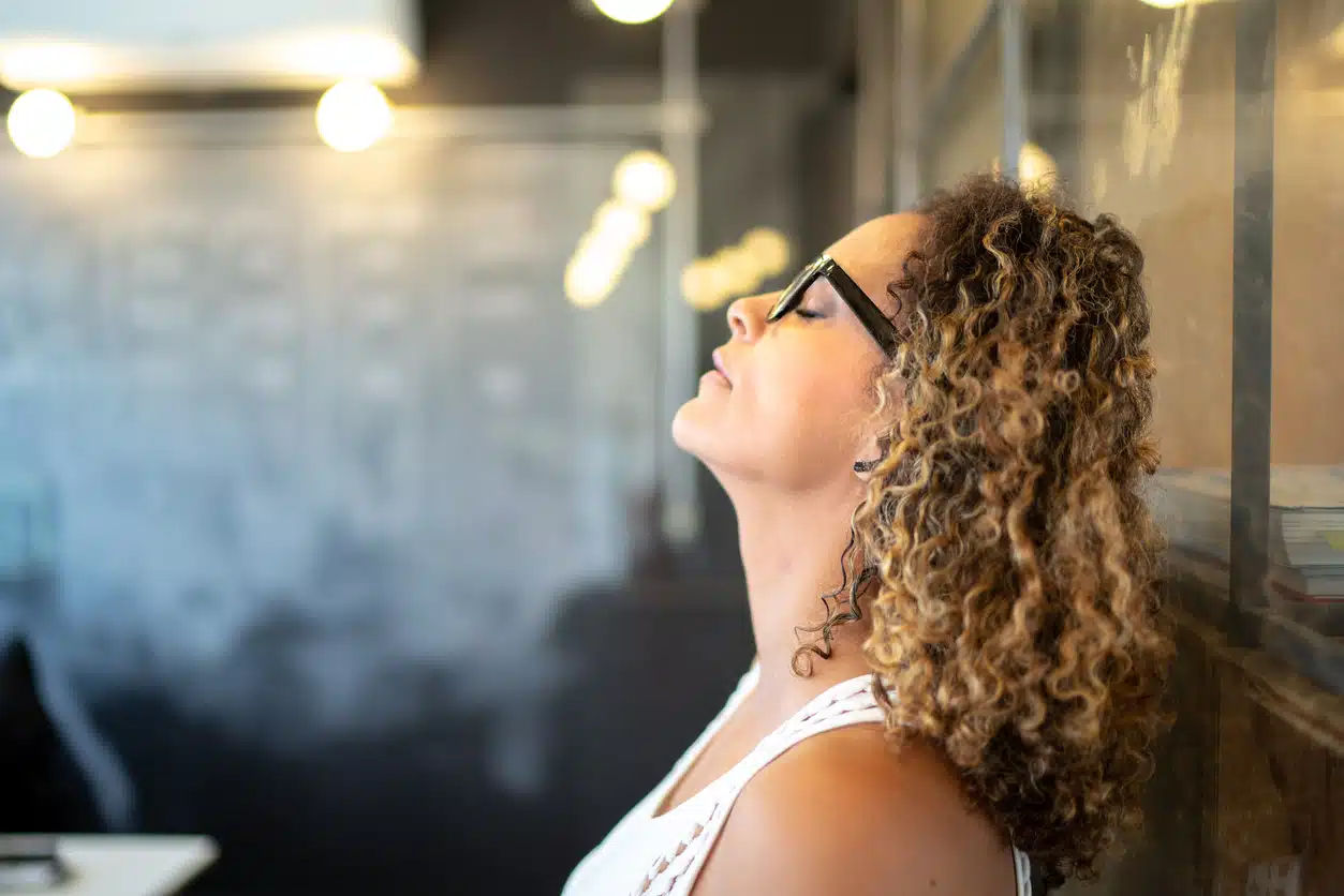 Tired woman leaning against wall to rest