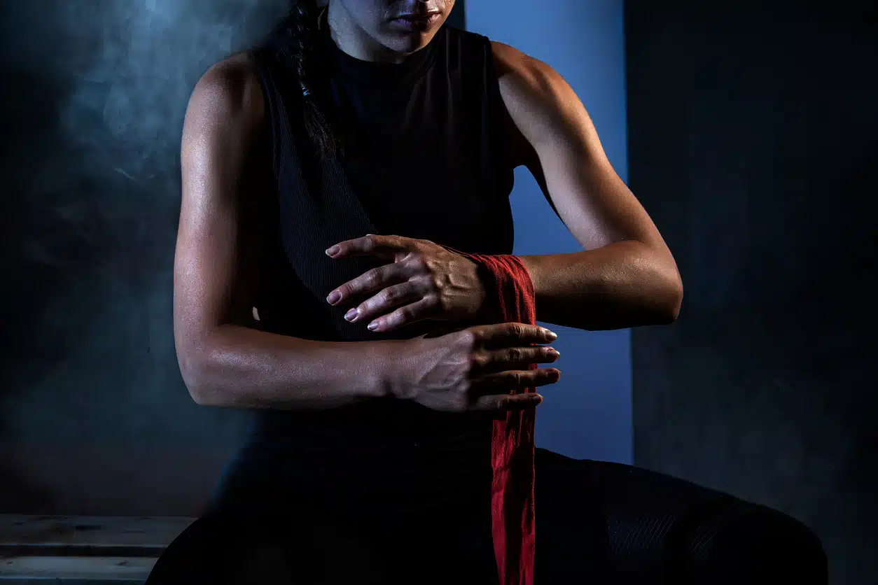 Muay Thai - Woman putting wraps on her hands before a workout